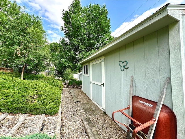 view of side of property featuring fence, an outdoor structure, and a shed