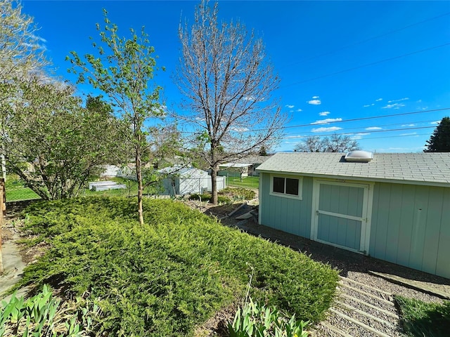 view of yard featuring a storage shed and an outdoor structure
