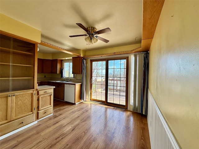 kitchen featuring a ceiling fan, light wood-style flooring, dishwasher, and light countertops
