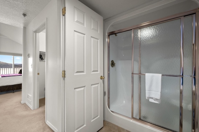 ensuite bathroom featuring a textured ceiling, ensuite bath, and a shower stall