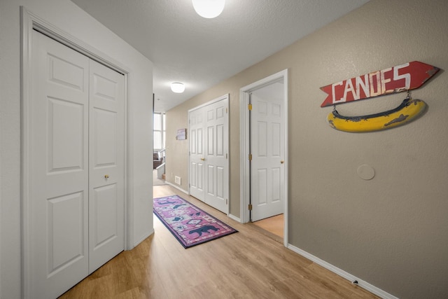hallway with baseboards and wood finished floors