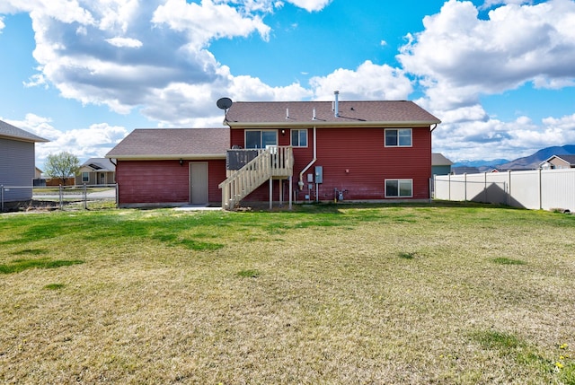 back of house featuring a lawn, stairs, and a fenced backyard
