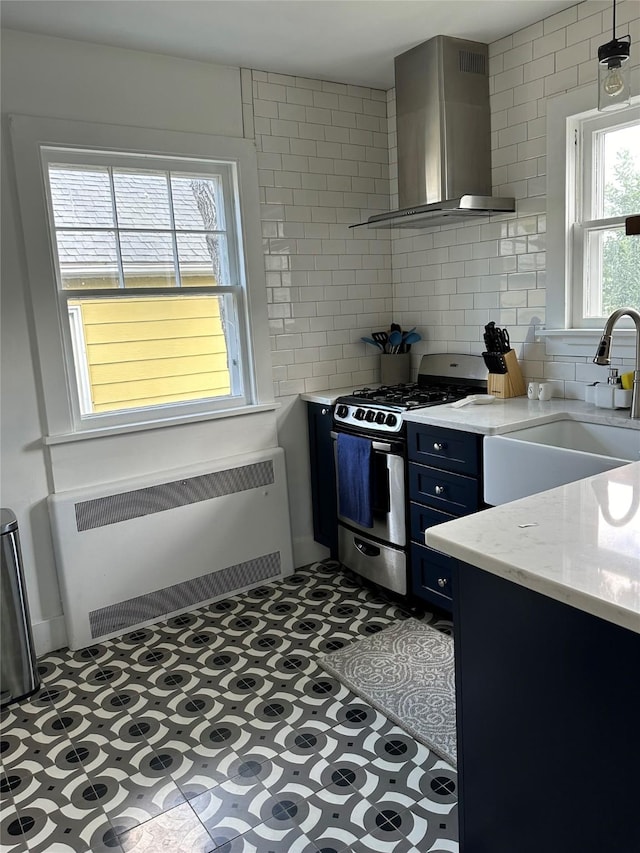 615 Dearborn Ave Unit 320Power, St, Helena, MT 59601 - kitchen featuring radiator, wall chimney range hood, stainless steel gas range, tile patterned floors, and a sink