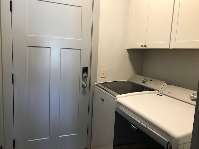 clothes washing area with cabinet space and washer and clothes dryer