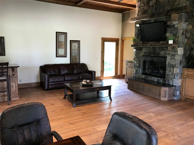 248 Forest Edge Trl, Kalispell, MT 59901 - living area with wood ceiling with exposed beams, a stone fireplace, light wood finished floors, and baseboards