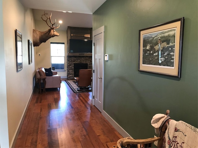 corridor featuring baseboards and wood finished floors