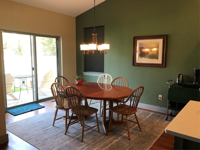 dining area featuring an inviting chandelier, baseboards, dark wood-type flooring, and vaulted ceiling