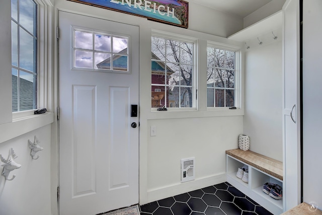 mudroom featuring dark tile patterned floors and baseboards