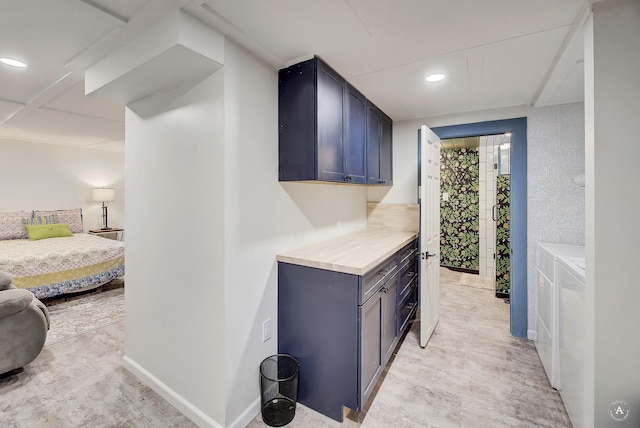 hall featuring light wood-style floors, recessed lighting, and independent washer and dryer