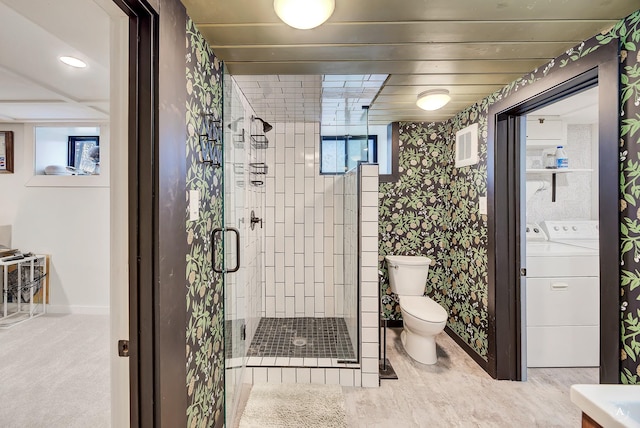 bathroom featuring visible vents, a stall shower, baseboards, toilet, and washer and clothes dryer