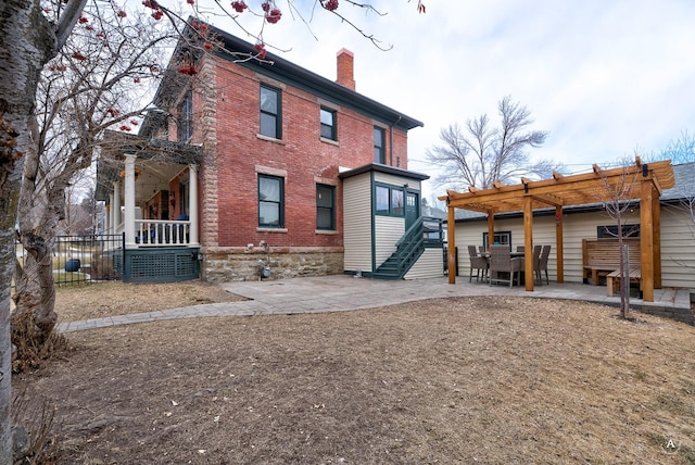 back of house with stairs, a pergola, brick siding, a chimney, and a patio