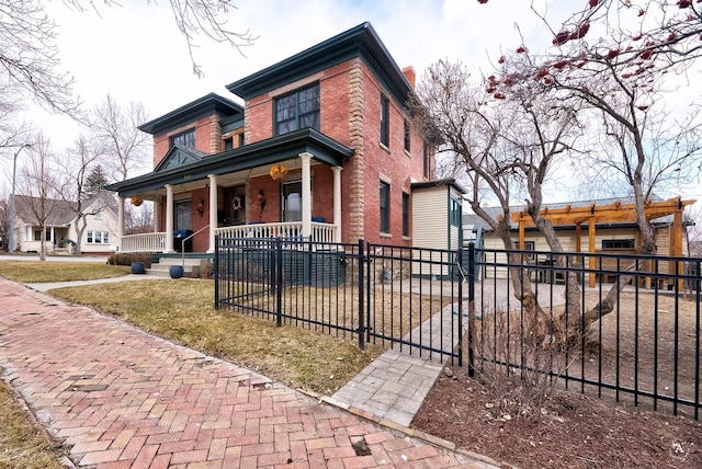 view of front of house featuring covered porch, a fenced front yard, a front yard, and brick siding