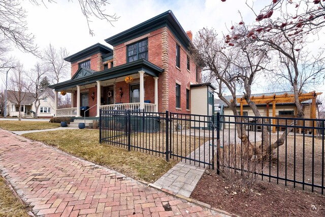 320 Power St, Helena, MT 59601 - view of front of house featuring covered porch, a fenced front yard, a front yard, and brick siding