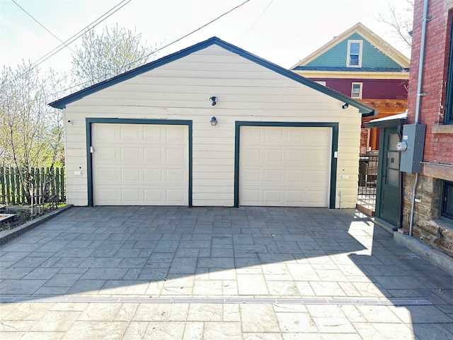 detached garage featuring fence
