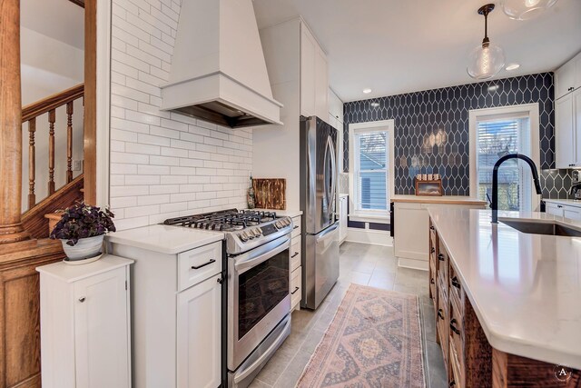 320 Power St, Helena, MT 59601 - kitchen featuring appliances with stainless steel finishes, tasteful backsplash, a sink, premium range hood, and light countertops