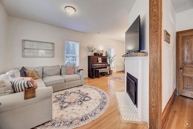 living area with light wood finished floors and a tile fireplace