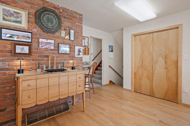 kitchen featuring baseboards, light wood-style flooring, and visible vents