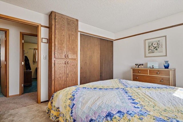 bedroom with light carpet, a closet, and a textured ceiling