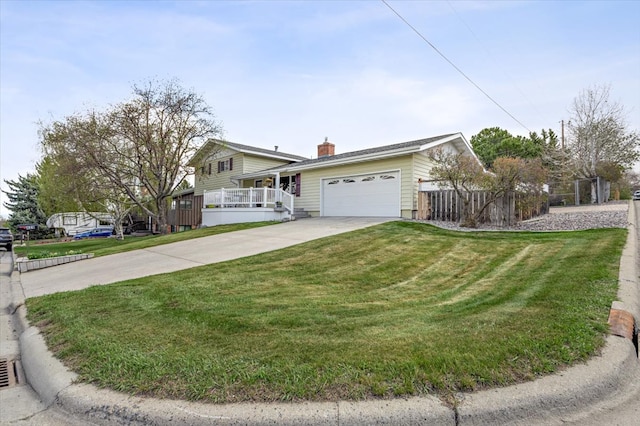 split level home with a chimney, a garage, fence, a front lawn, and concrete driveway