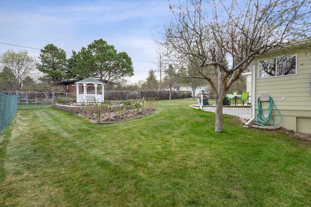 view of yard with fence, a wooden deck, and a gazebo