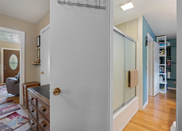 full bathroom featuring baseboards, combined bath / shower with glass door, wood finished floors, and vanity