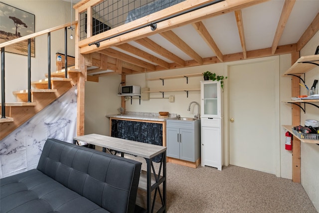 kitchen with light countertops, open shelves, light colored carpet, and a sink