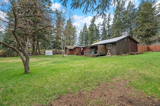view of yard with fence, an outbuilding, and a storage unit