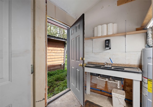 doorway to outside featuring unfinished concrete flooring and electric water heater