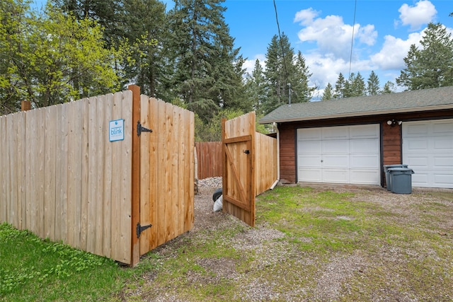 detached garage featuring a gate and fence