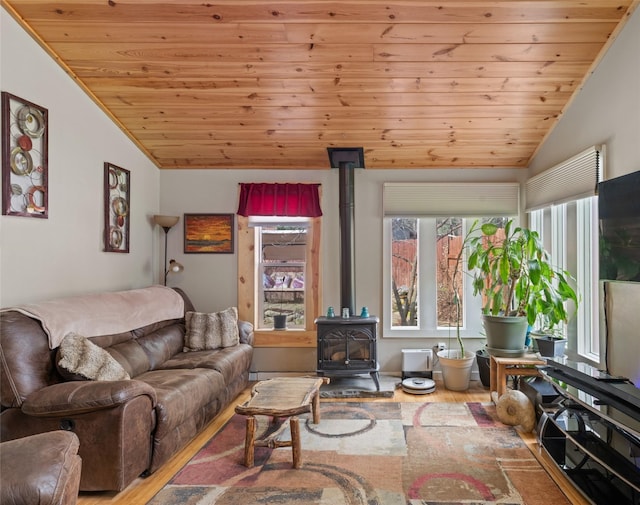 living area with a wood stove, wood ceiling, wood finished floors, and vaulted ceiling