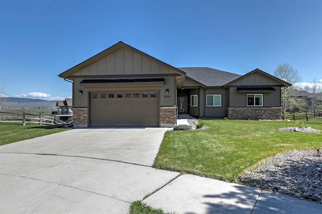 view of front facade with driveway, a front yard, a garage, fence, and stone siding