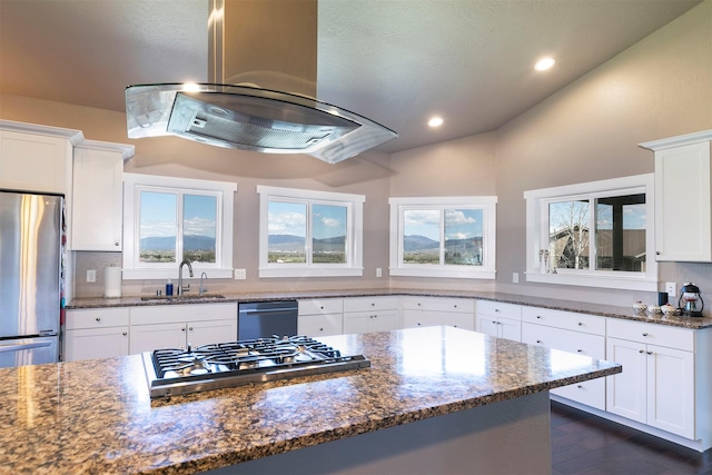kitchen featuring lofted ceiling, island range hood, a sink, dark stone countertops, and appliances with stainless steel finishes