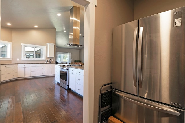 kitchen with wall chimney range hood, dark wood-type flooring, recessed lighting, white cabinets, and stainless steel appliances