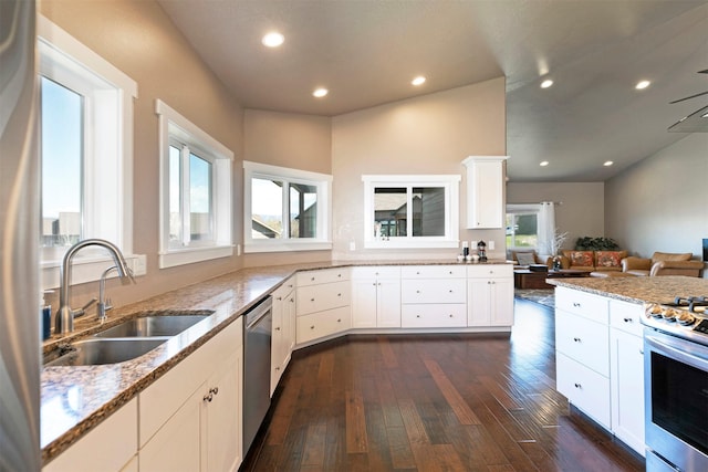 kitchen with a sink, light stone countertops, dark wood finished floors, and open floor plan