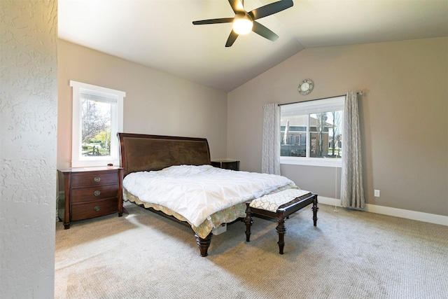 bedroom featuring ceiling fan, multiple windows, lofted ceiling, and light carpet