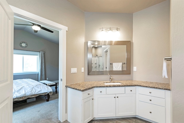 bathroom featuring ceiling fan, ensuite bathroom, lofted ceiling, and vanity