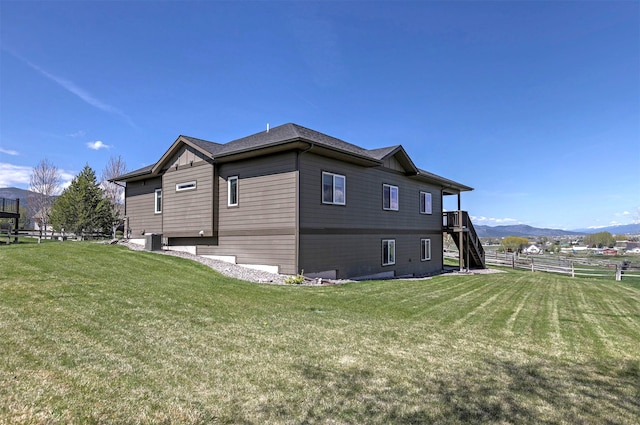 view of property exterior with stairs, fence, a yard, and cooling unit