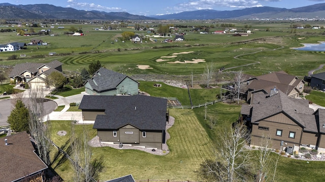 drone / aerial view featuring a water and mountain view, view of golf course, and a residential view