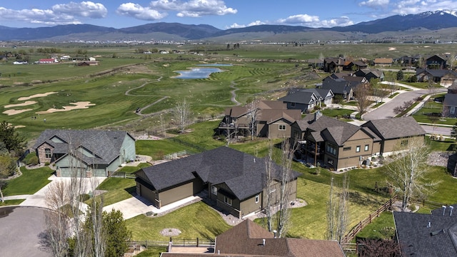 aerial view featuring a water and mountain view, view of golf course, and a residential view