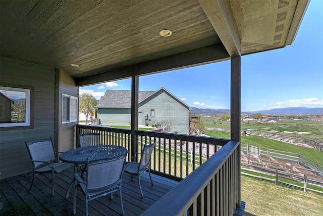wooden terrace with a mountain view and outdoor dining area