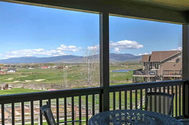 balcony featuring a water and mountain view