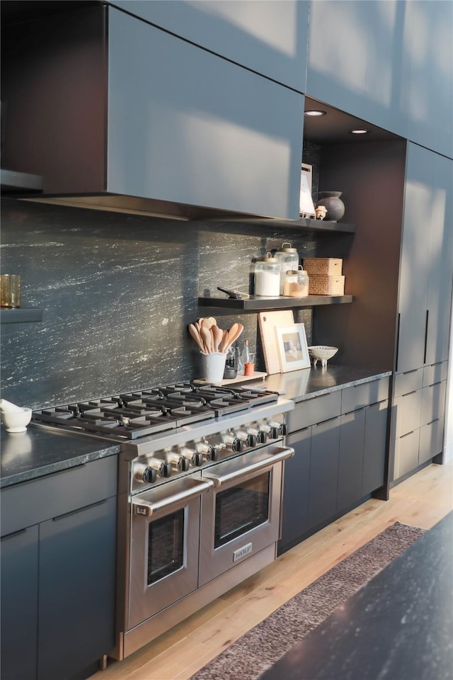 kitchen featuring tasteful backsplash, light wood finished floors, modern cabinets, and double oven range