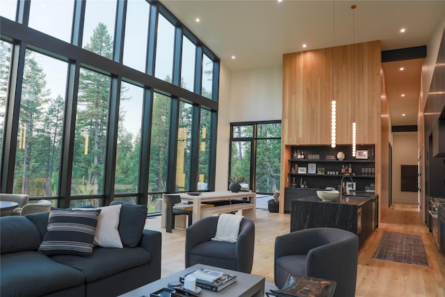 dining room featuring light wood-style floors and a towering ceiling
