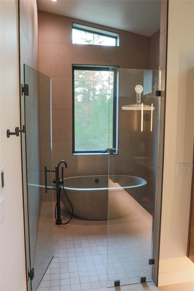 full bath with tile patterned flooring, a soaking tub, and a shower stall