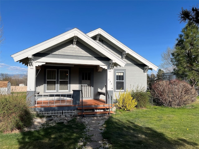 bungalow with a front lawn and covered porch