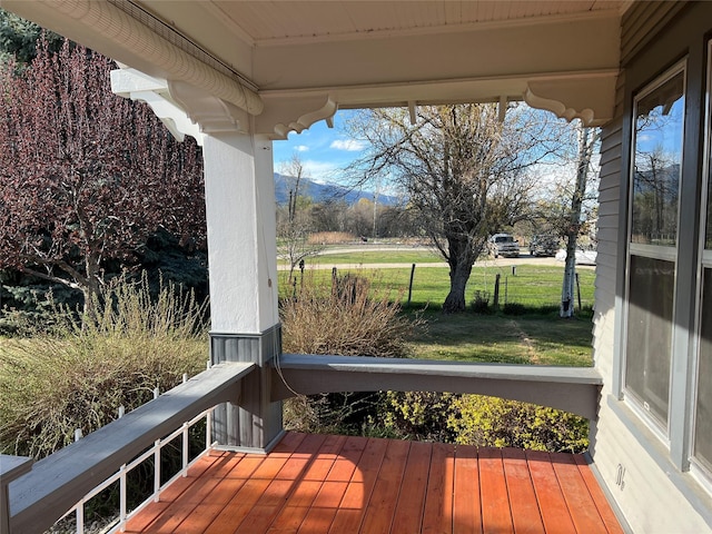 wooden deck with a lawn and a mountain view