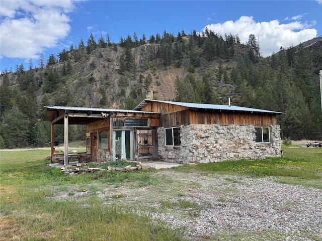 9536 Mt Highway 200, Plains, MT 59859 - view of front facade with a mountain view, a wooded view, and stone siding
