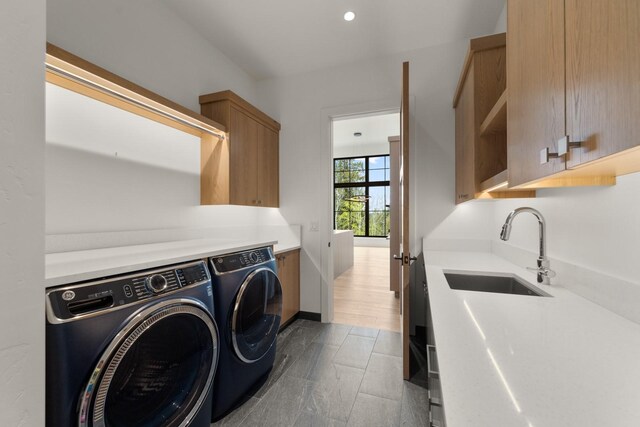 laundry room featuring cabinet space, recessed lighting, a sink, and washer and clothes dryer