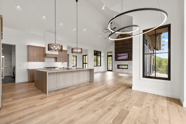 176 S Shooting Star Cir, Whitefish, MT 59937 - kitchen featuring high vaulted ceiling, open floor plan, light countertops, a chandelier, and a spacious island