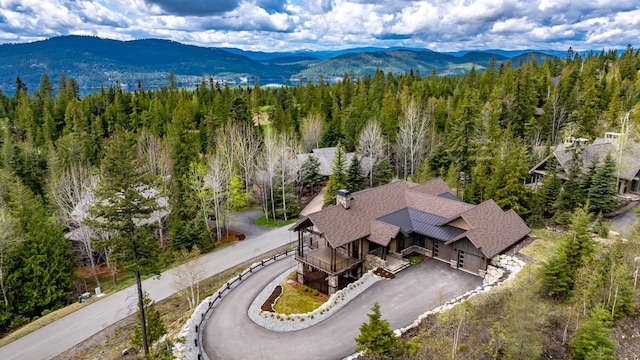 drone / aerial view featuring a wooded view and a mountain view